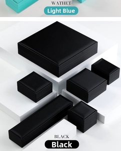Macro shot of black textured PU leather jewelry boxes on a white geometric display