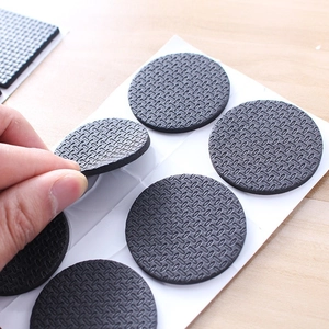 Non-slip black EVA foam furniture pads with diamond texture on wooden table