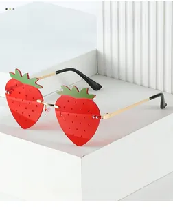 Close-up of strawberry-shaped rimless sunglasses with red lenses and gold metal stems