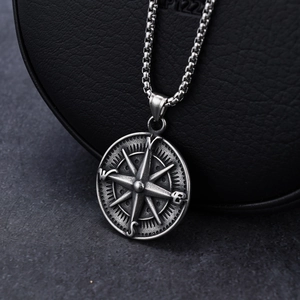 Vintage stainless steel compass pendant with distressed finish on black leather base