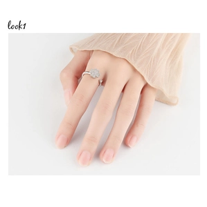 Detailed close-up of a rotating clover ring with white zircon stones on a female finger
