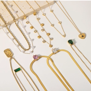 Collection of layered gold necklaces with pearl, sun, moon pendants and colorful zircons