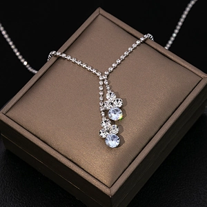 Macro shot of silver bridal necklace with teardrop rhinestones on bronze jewelry box