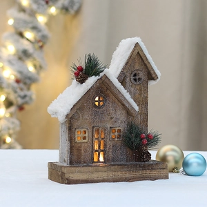 Macro detail of wooden Christmas house with snow roof, pine cones and warm LED lights