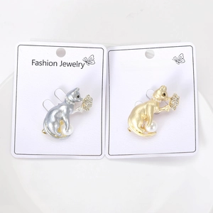 Detailed macro view of silver and gold cat brooches with pearls and sparkling crystals