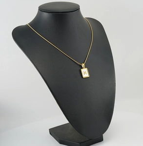Detail of 18K gold stainless steel Pisces zodiac square pendant on a snake chain