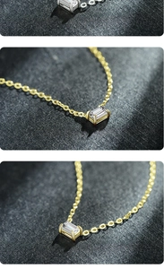 Macro view of gold necklace with emerald-cut zircon pendant in four-prong setting