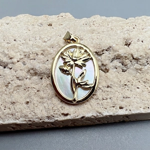 Detail of vintage gold oval flower pendant with iridescent mother of pearl inlay