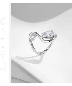 Close-up of S925 sterling silver ring featuring wave design with pear and round crystals