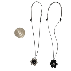 Minimalist black onyx beaded flower pendant necklace with long cord on white background