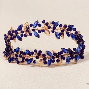 Detail of baroque headband featuring golden leaves and sparkling deep blue crystal beads