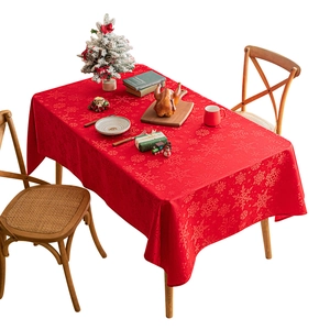 Christmas tablecloth with red snowflake patterns on wooden table for festive dining decoration