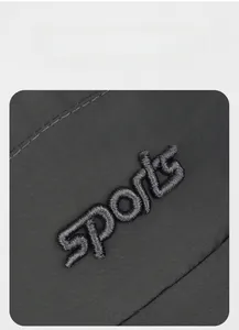 Macro detail of high-density black nylon fabric with 3D embroidery showing sports logo