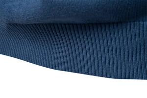 Gros plan des poignets côtelés bleu foncé d'un pull en coton avec une maille serrée