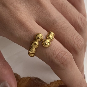 Close-up of adjustable gold-plated stainless steel ring featuring minimalist polished beads