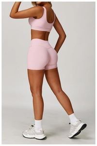 Detail of light pink yoga set showing back support bra and high-waisted shaping shorts