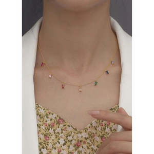 Gold s925 silver necklace featuring multi-color zircon stones worn by a model