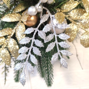 Gros plan de guirlande de Noël avec feuilles pailletées dorées et argentées