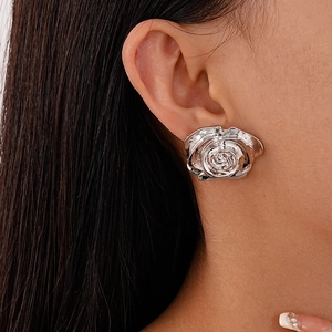Gros plan détaillé d'une boucle d'oreille rose métallique portée par un mannequin