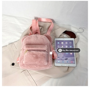 Detailed comparison of pink plush mini backpack with ears next to an iPad for size reference