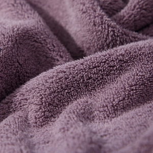 Macro shot showing soft thickened purple coral fleece fabric texture and high fiber density