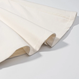 Nahaufnahme des cremeweißen Wolljackensaums mit hochwertiger Stricktextur und feinen Nähten