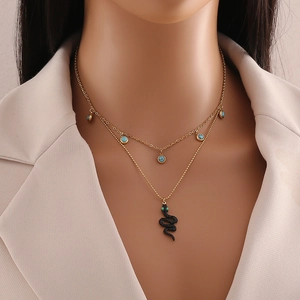 Close-up of double-layer gold necklace with turquoise beads and black snake pendant on model