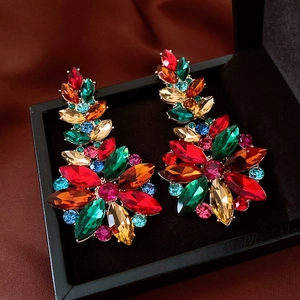 Macro shot of vintage style floral earrings with colorful crystal inlay on dark silk