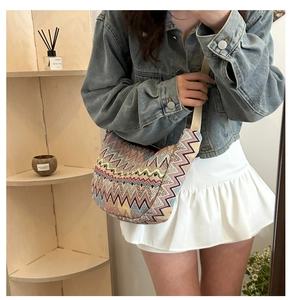 Détail du sac bandoulière tissé avec motifs à vagues et large bandoulière élégante