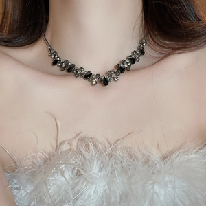 Detailed close-up of a silver-toned teardrop necklace with black and clear crystals