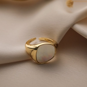 Minimalist 18K gold plated ring with white mother of pearl inlay on silk background