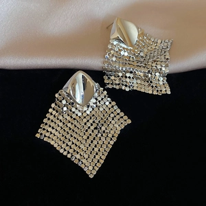 Macro detail of silver geometric rhombus earrings with delicate metal mesh tassels