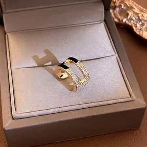 Golden double-layered C-shape ear cuff with black enamel and sparkling zircons