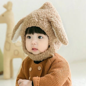 Close-up of soft brown plush baby hat with cute long rabbit ears and warm fleece texture