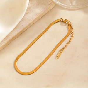 Minimalist 18KGP gold flat snake bone anklet chain with lobster clasp on beige background