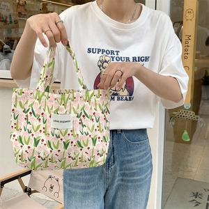 Détail du sac cabas en toile à fleurs avec motifs tulipes roses et étiquette tissée