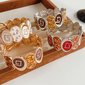 Détails de bracelets vintage en émail avec logo G sur un plateau de présentation en velours