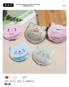 Flat lay of cat-shaped quicksand makeup mirrors in five colors on a wooden background