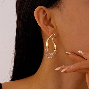 Close-up of gold-plated vintage resin earring in fluid drop shape on female model
