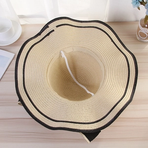 Detail view of woven straw sun hat showing interior lining and elastic windproof strap