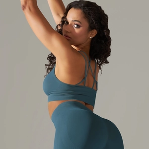 Close-up of seamless dark teal yoga set featuring crisscross back bra and ribbed leggings