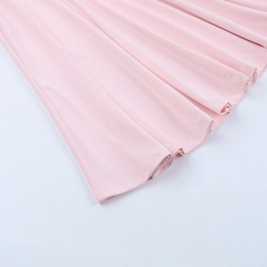 Gros plan sur l'ourlet de la robe en maille rose clair avec coutures précises