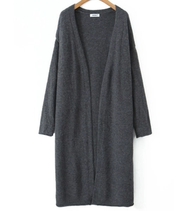 Detail of a long dark grey knitted cardigan with an open front on a wooden hanger