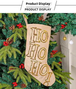 Macro shot of burlap Christmas stocking featuring gold sequins HO HO HO text decoration