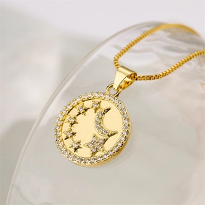 Detailed close-up of a gold necklace pendant featuring moon and stars with zircon accents