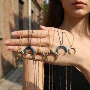 Detail of bohemian crescent moon necklaces with micro-inlaid zircons and colorful enamel