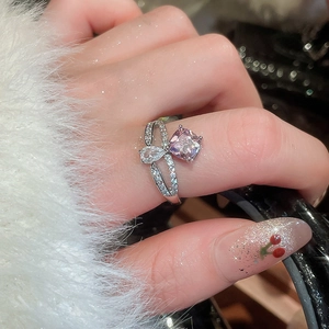 Macro detail of criss-cross ring with square pink stone and pear drop zircon accents