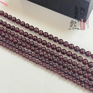 Vue macro des perles de grenat rouge foncé de 4-10mm avec une finition lisse et brillante