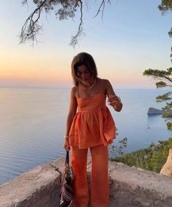 Détail d'un ensemble orange deux pièces avec haut à bretelles et pantalon large
