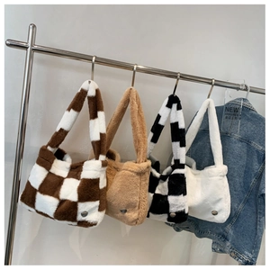 Detail view of plush handbags in assorted plaid patterns and solid colors on a display rack